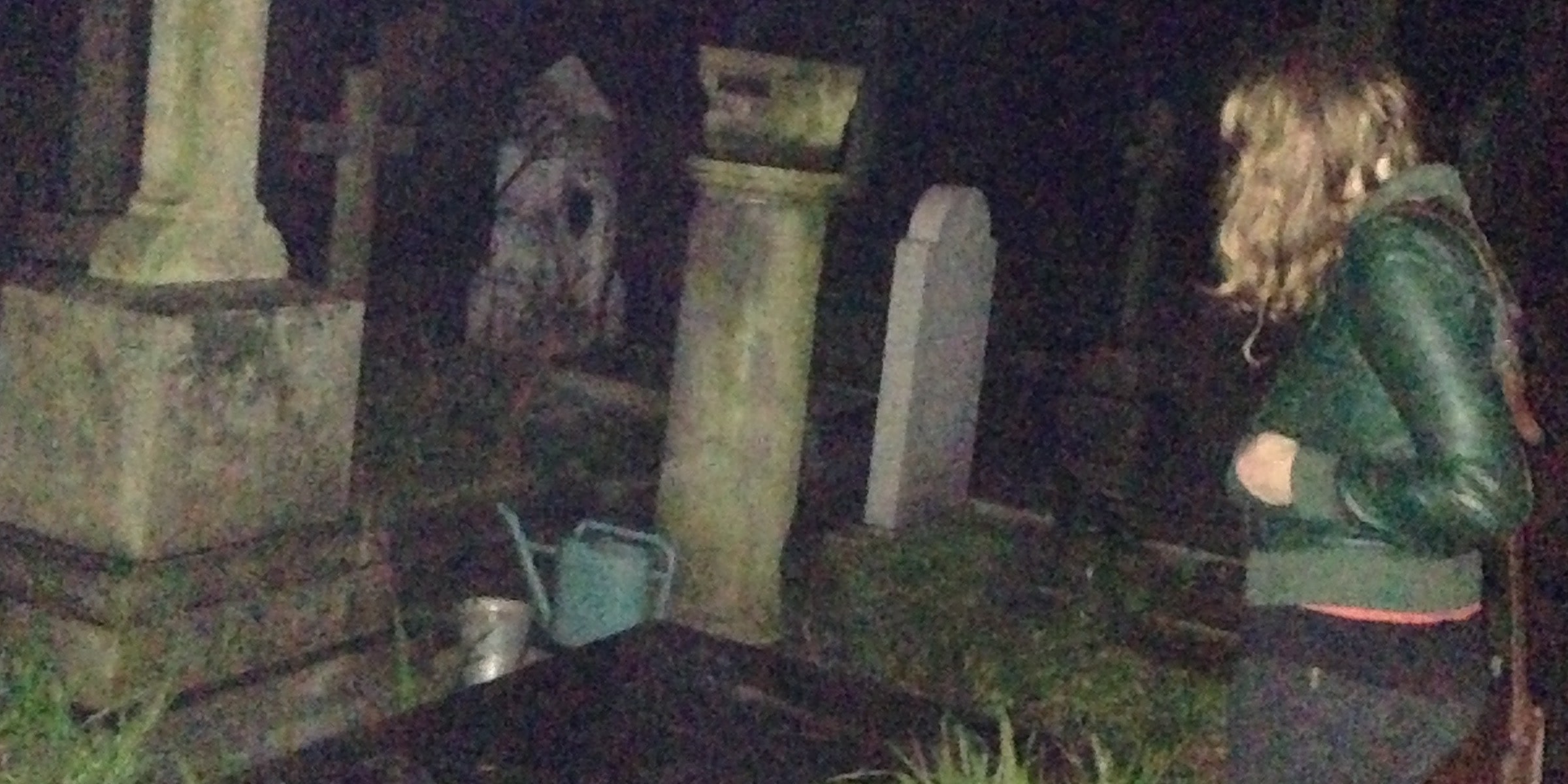 Photo of Eva looking at a gravestone